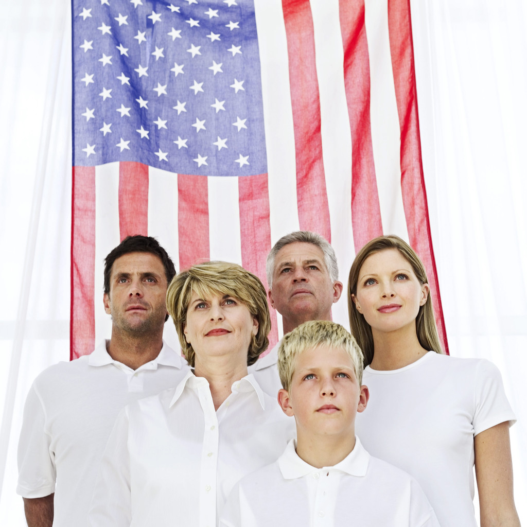 Family Standing in Front of the American Flag --- Image by © Royalty-Free/Corbis